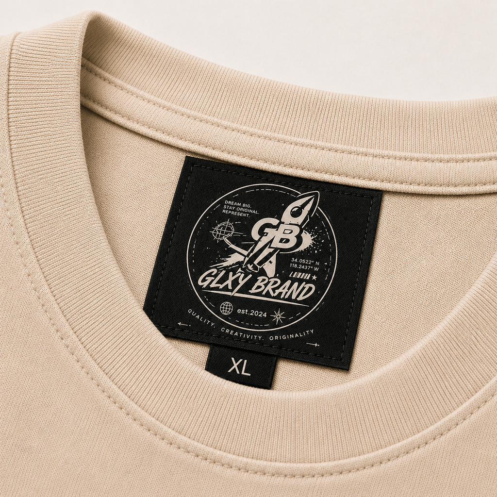 Close-up of the woven neck label inside the GLXY Orbit 001 Vintage Cream t-shirt