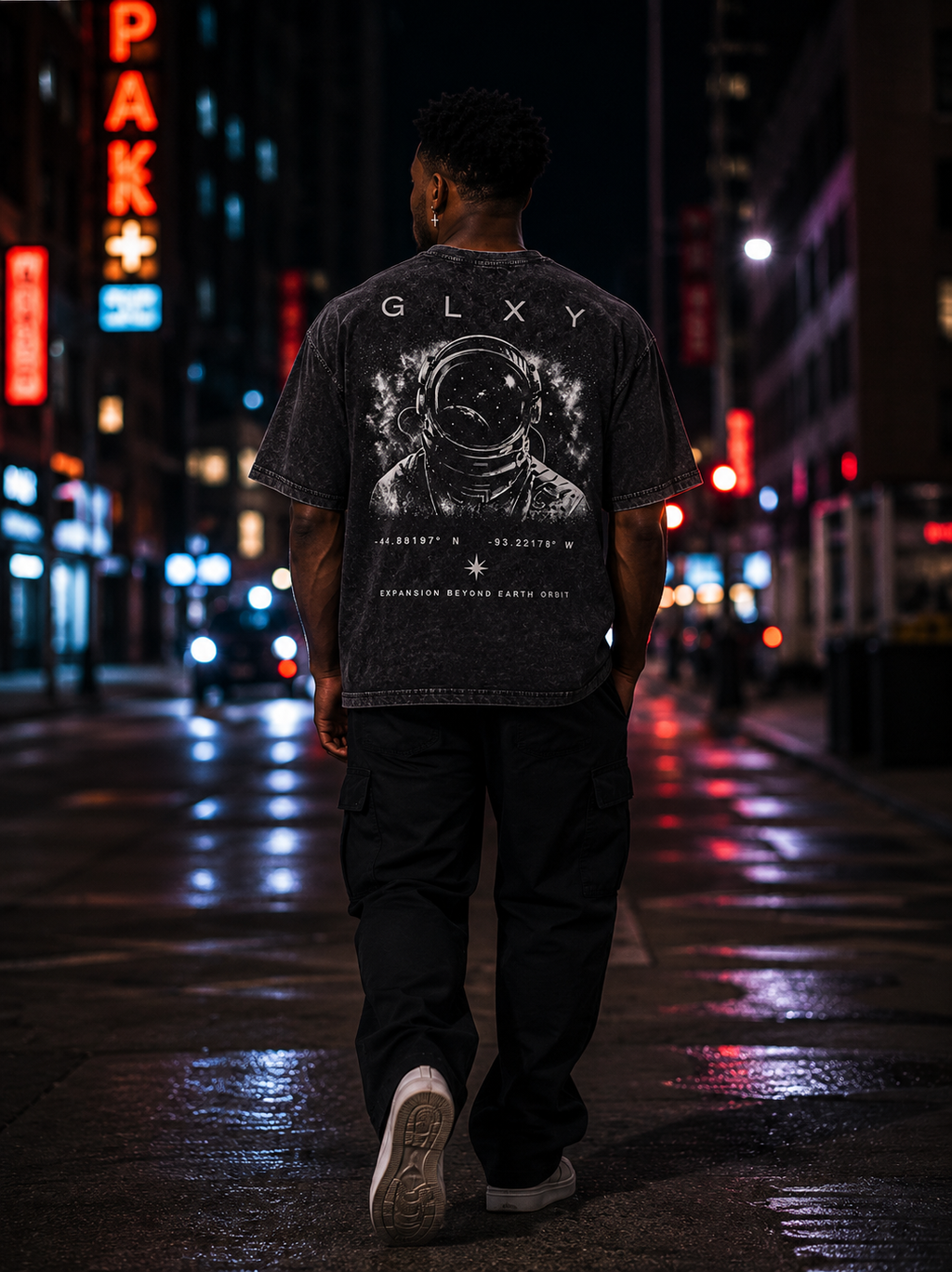 Male model back view wearing the GLXY Orbit 001 Vintage Black t-shirt featuring astronaut artwork