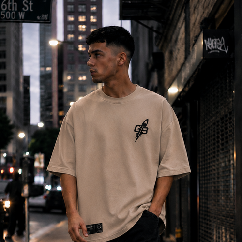 Model wearing the GLXY Orbit 001 Vintage Cream heavyweight acid-wash t-shirt while walking through a city street