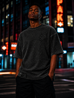 Model wearing the GLXY Orbit 001 Vintage Black t-shirt while walking through a city street