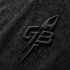 Close-up of the tonal puff-print GB rocket emblem on the GLXY Orbit 001 Vintage Black t-shirt