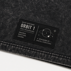 Close-up of the woven waistline tag on the GLXY Orbit 001 Vintage Black t-shirt