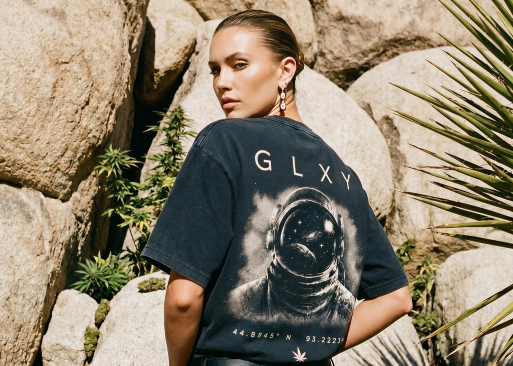 Female model wearing the GLXY Orbit 001 Vintage Black heavyweight acid-wash t-shirt with puff-print GB rocket emblem