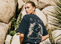 Female model wearing the GLXY Orbit 001 Vintage Black heavyweight acid-wash t-shirt with puff-print GB rocket emblem