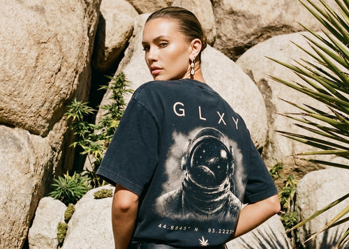 Female model wearing the GLXY Orbit 001 Vintage Black heavyweight acid-wash t-shirt with puff-print GB rocket emblem